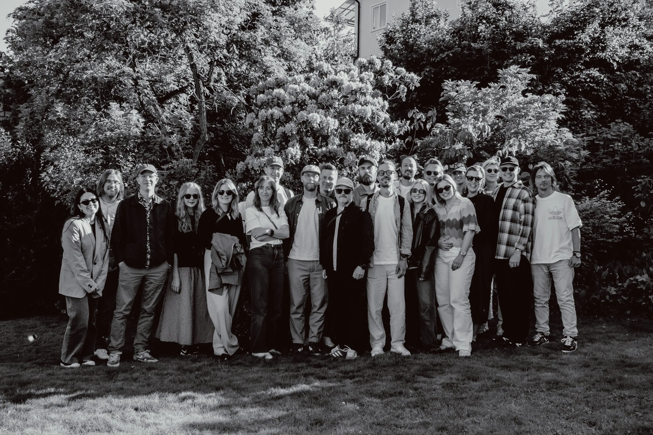 The Grand Public team gathered outdoors in front of greenery